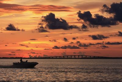 Scenic view of sea against dramatic sky during sunset