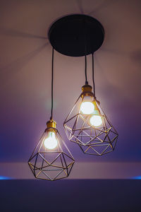 Close-up of illuminated light bulb hanging on wall