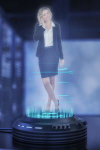 Digital composite image of woman standing against illuminated building