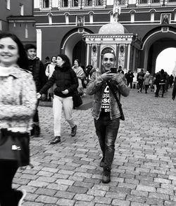 Group of people walking on street in city