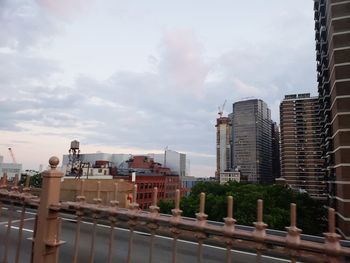 Buildings in city against cloudy sky