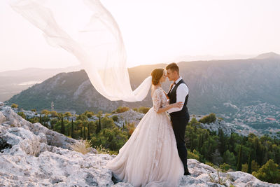 Couple kissing against mountain