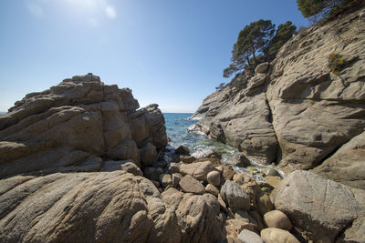 Rocks on beach against clear sky