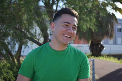 Portrait of smiling young man against trees