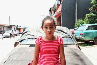 Portrait of smiling young woman on car