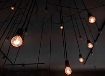 Low angle view of illuminated pendant lights hanging from ceiling
