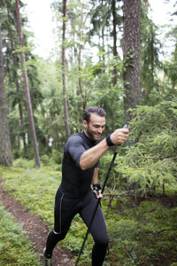 Mid adult man running through forest