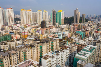 Aerial view of buildings in city against sky