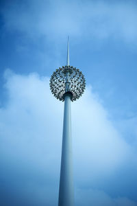 Low angle view of communications tower against cloudy sky