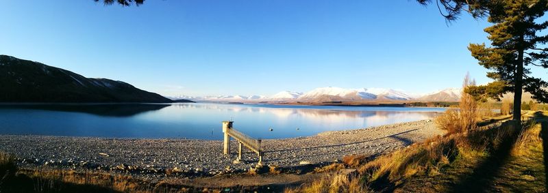 Scenic view of lake against clear blue sky