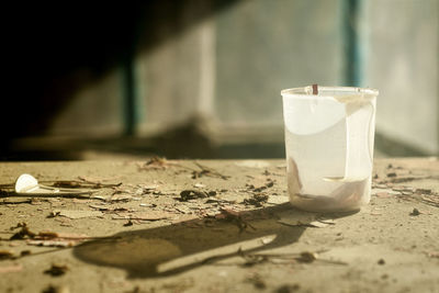 A still life image with an old plastic mug on a devastated table. 