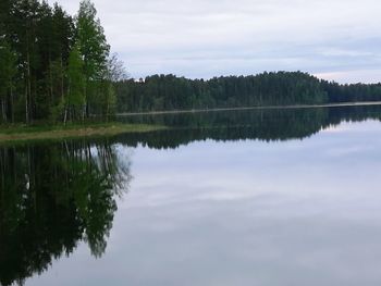 Scenic view of lake by trees against sky