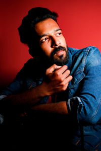 Portrait of young man sitting on bed at home