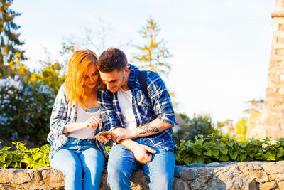 Young couple sitting outdoors