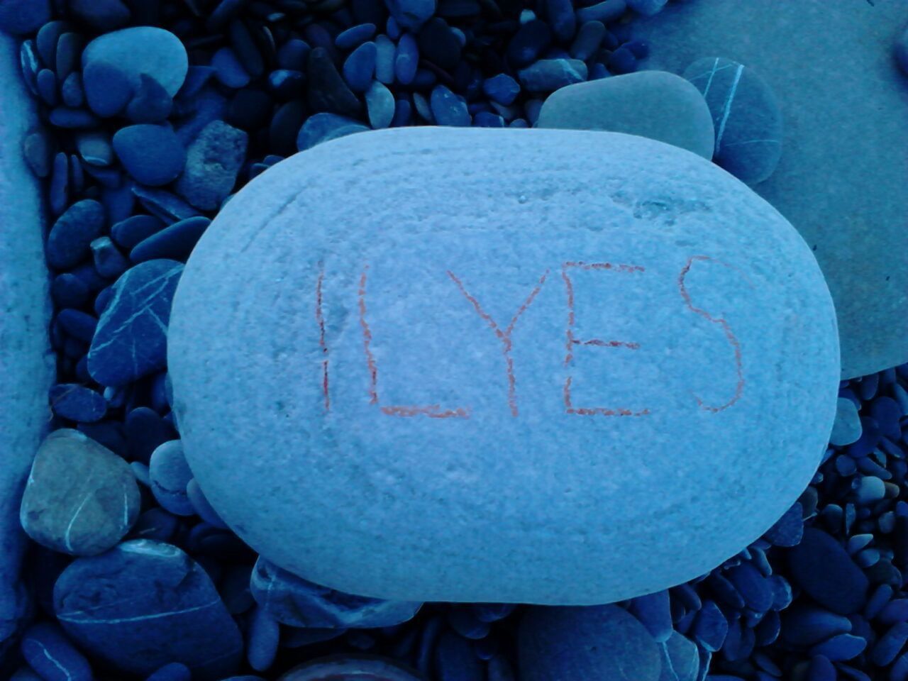 close-up, text, stone - object, communication, large group of objects, abundance, blue, stack, outdoors, day, rock - object, stone, western script, no people, sphere, pebble, circle, shape, textured, heap