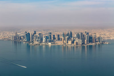 Aerial view of buildings in city against sky