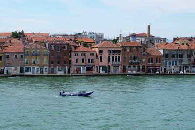 Boats in river with town in background