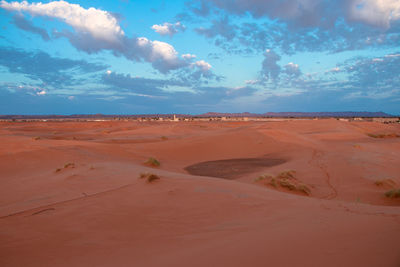 View of desert against cloudy sky