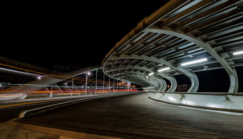 Illuminated footbridge in city at night