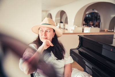 Side view of young woman looking through window