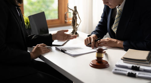 Midsection of lawyer working at desk in office