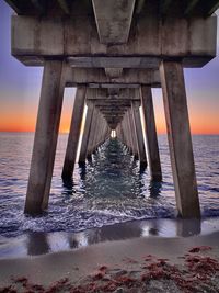 Pier over sea against sky during sunset