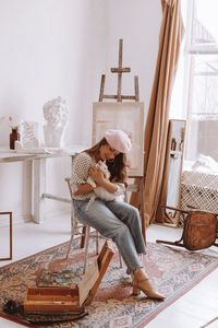 Young woman sitting on bed at home