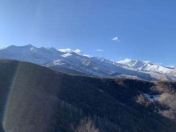 Scenic view of snowcapped mountains against clear blue sky