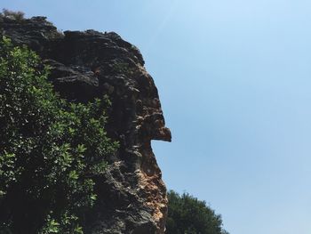 Low angle view of rocky mountains against clear sky