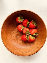 Eight strawberries in a grained wooden bowl. fresh, red, juicy, sweet, nutritious, summer fruit.