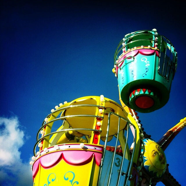 low angle view, blue, yellow, sky, multi colored, clear sky, no people, metal, outdoors, protection, amusement park ride, day, close-up, built structure, amusement park, metallic, architecture, safety, copy space, green color