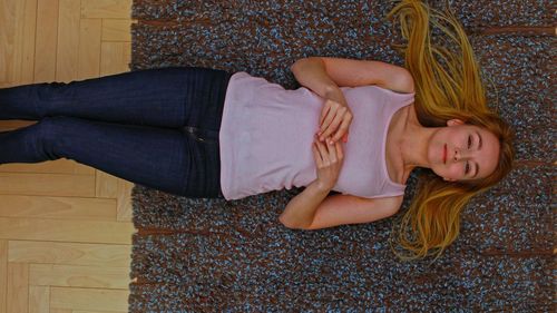 Portrait of woman lying down on floor at home