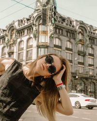 Portrait of woman wearing sunglasses in city
