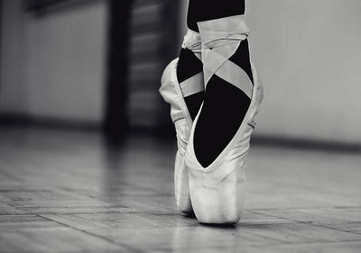 Low section of ballet dancer dancing on floor