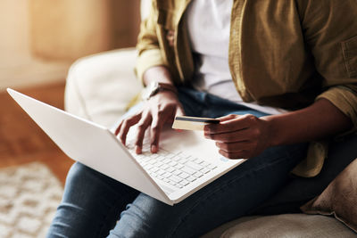 Midsection of woman using laptop