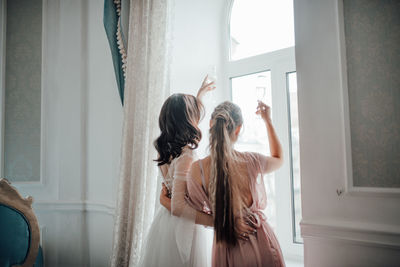 Rear view of woman standing at home