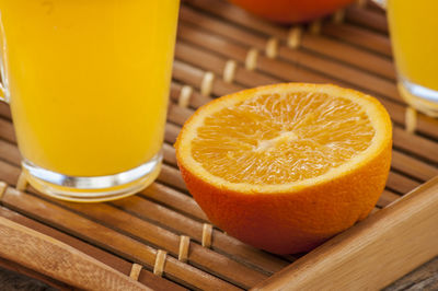 Orange slice with juice glass in serving tray