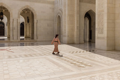 Full length of woman standing at historic building