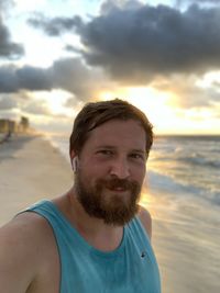 Portrait of smiling man on beach during sunset