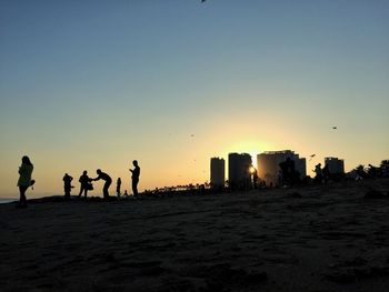 Silhouette of people standing on beach