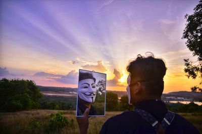 Portrait of man standing against sky during sunset