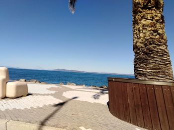 Scenic view of beach against clear blue sky