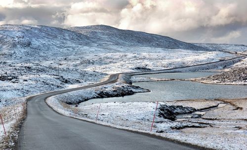 Road crossing lakes and snowy hill in northern norway