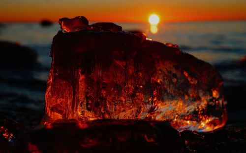 Close-up of rock on shore during sunset