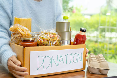 Midsection of woman holding food on table