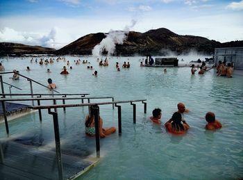 People enjoying in water against sky