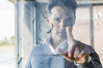 Businessman touching transparant projection screen in office