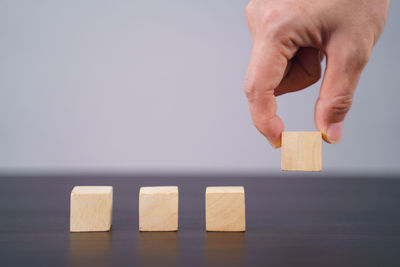 Midsection of person with toy on table against gray background