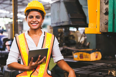 Portrait of smiling man standing at construction site