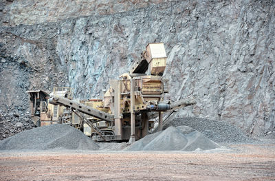 Coal mining machinery amidst heaps